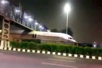 Air india plane gets stuck under foot over bridge near airport