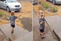 Little boy dances in the rain for the very first time as downpour soaks fire ravaged nsw
