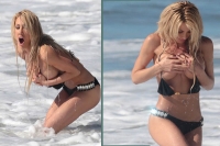 Bombshell blasted out of bikini by rogue wave