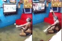 Viral video man takes bath in hall watching tv ponded with flood water