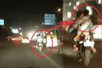 Young couple romance on bike mid traffic jam in delhi