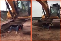 Tradesman bench presses an excavator weighing 30 tonnes on a construction site