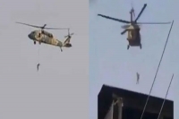 Taliban flying a us black hawk helicopter with a body hanging from it