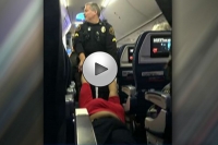 Woman dragged off flight by officials